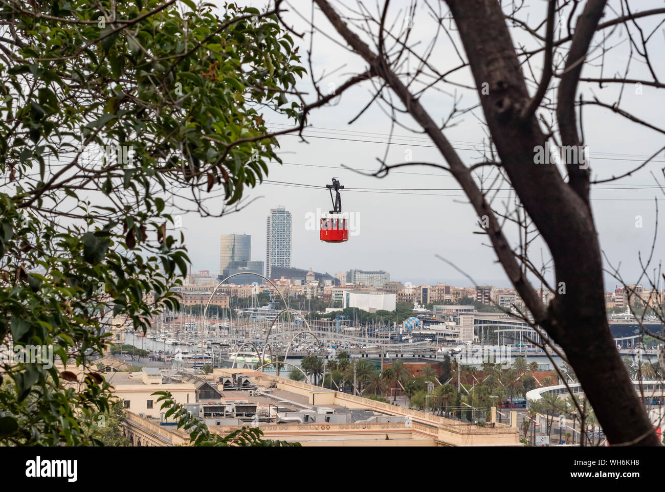 Iconic Barcelona's red aerial cableway moving over Port Vell. The red Funicular. Stock Photo