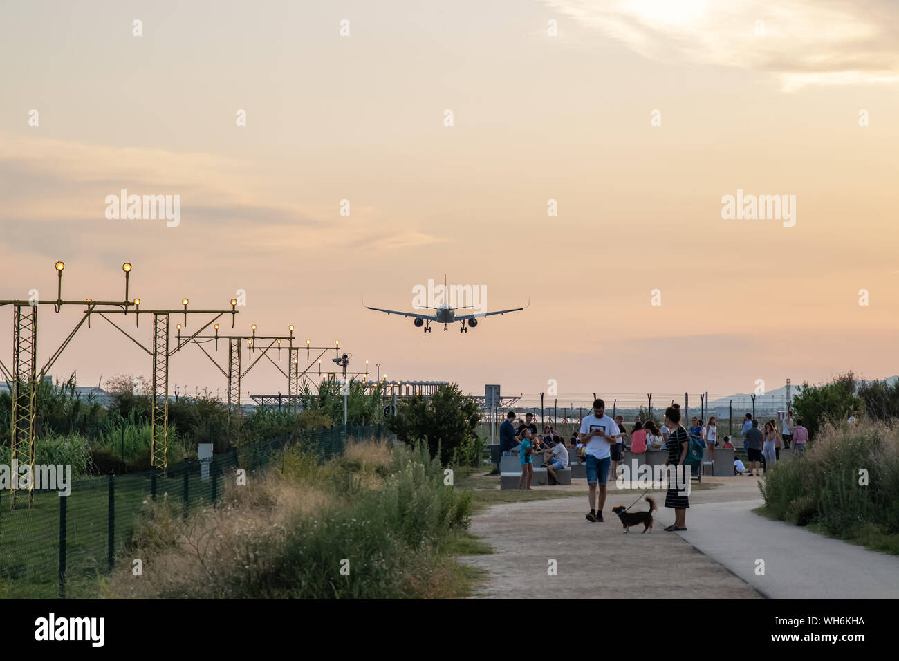 Aircraft landing in El Prat Barcelona airport overflying a group of people Stock Photo
