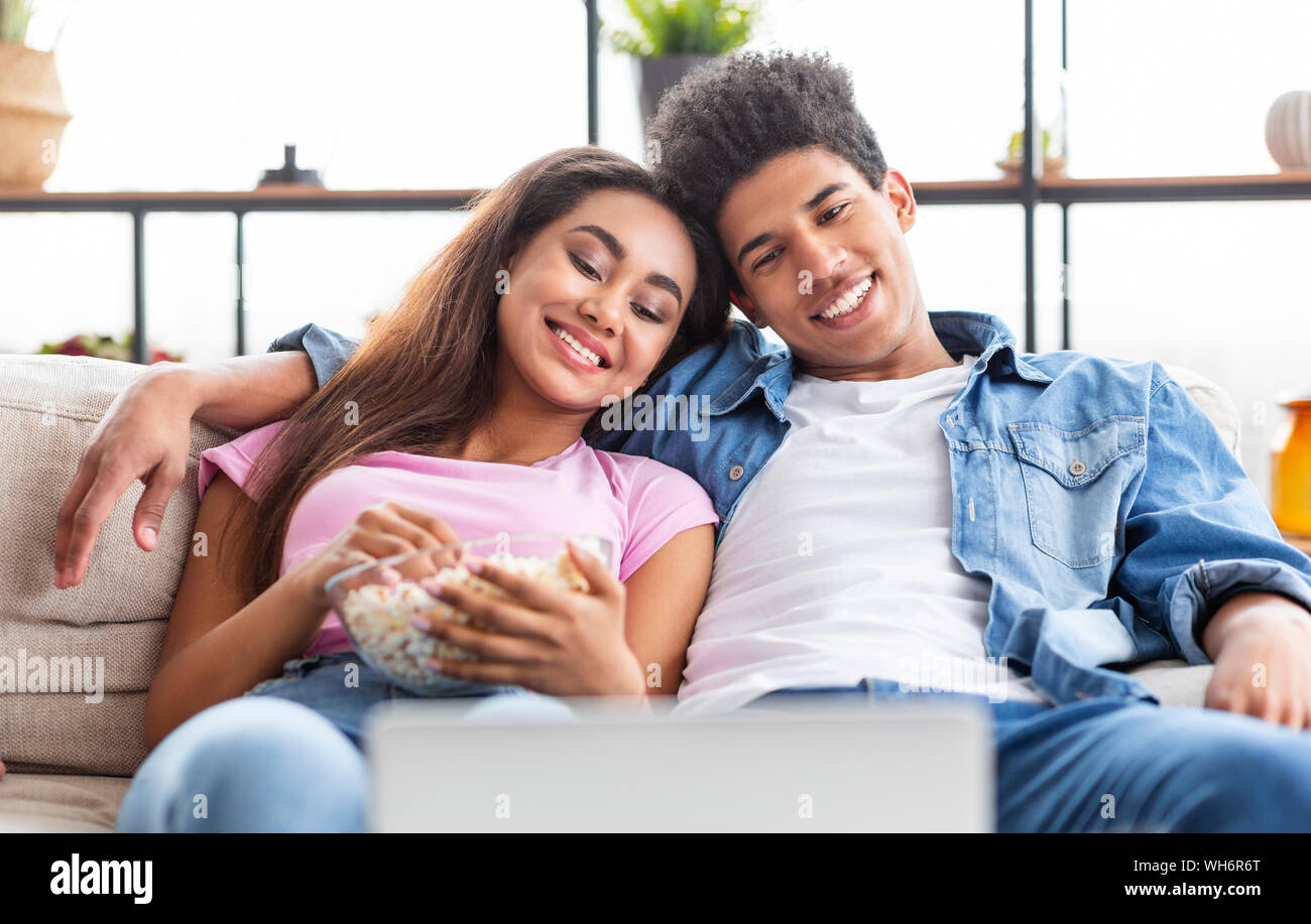 Couple of teenagers watching movie on laptop at home Stock Photo
