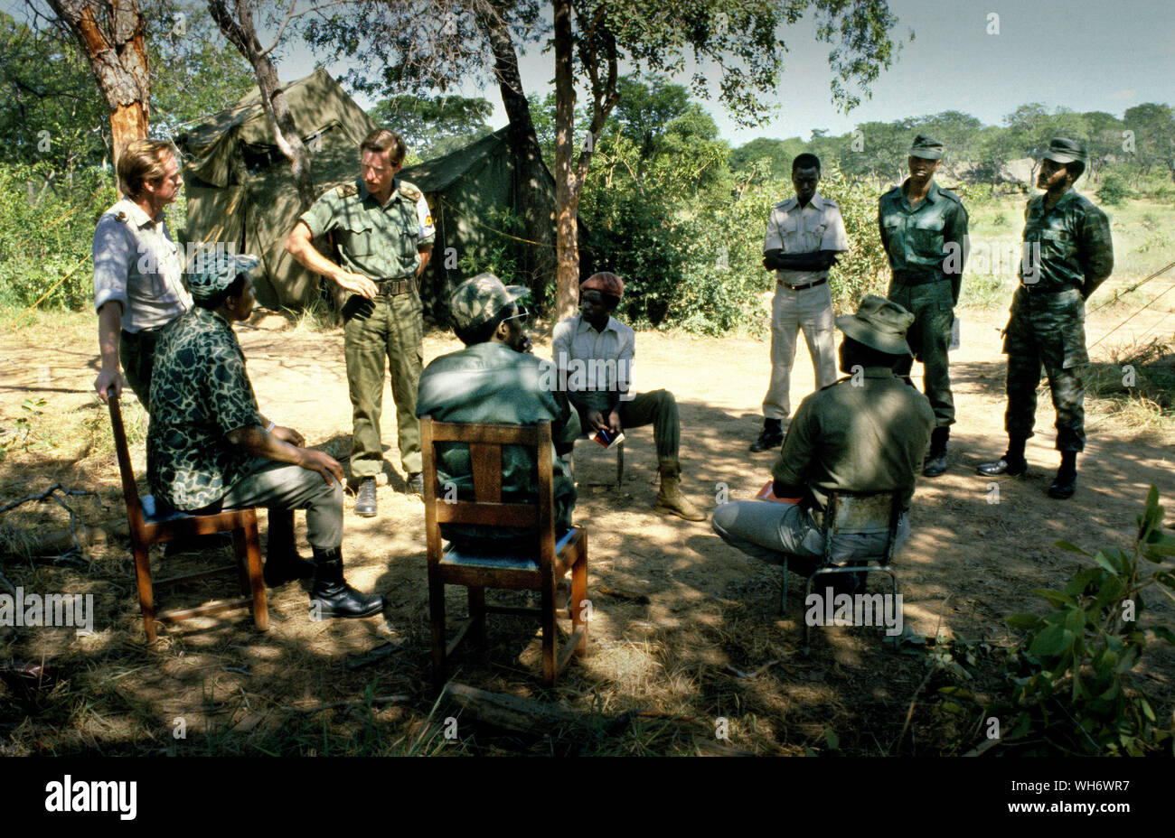 Lt Colonel Andrew Parker Bowles, on left, at Camp Alpha, Rhodesia-Zimbabwe 1980. He is seen supervising the Patriotic Front troops coming in from the bush into British Army run holding camps in the Zambezi valley as part of the Lancaster House peace process after the Rhodesian civil war ended.  He was Senior Military Liaison Officer to Lord Soames, when he was Governor of Rhodesia during its transition to the majority rule state of Zimbabwe in 1979–1980. He was staff qualified (sq), and became a Lieutenant-Colonel 30 June 1980.AK47AK47 He was awarded the Queen's Commendation fo Stock Photo