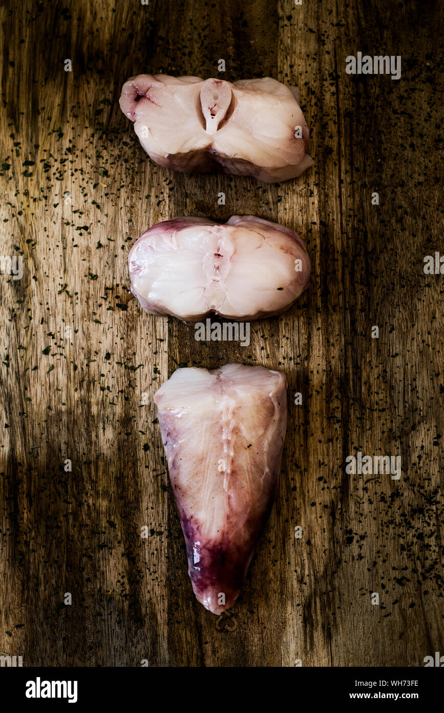 high angle view of some slices of raw monkfish on a rustic wooden table Stock Photo