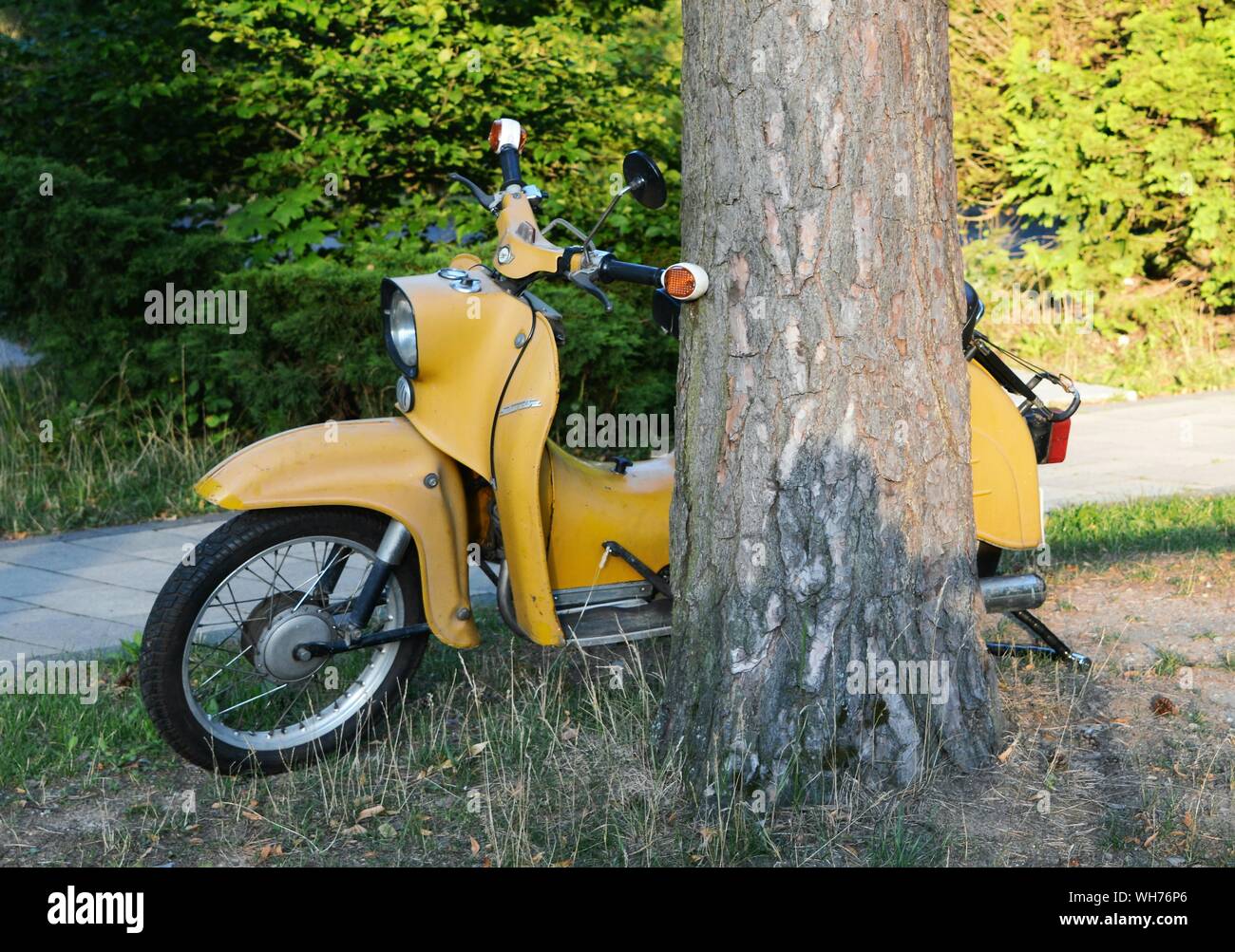 Yellow miniature 4\u201d long moped scooter with glittered snowman with Christmas decorated tree