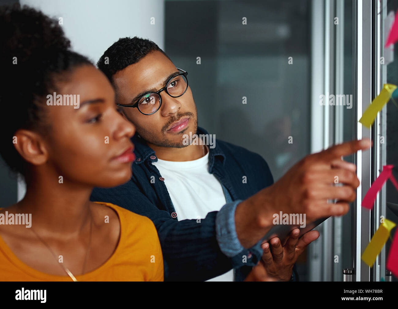Businesswoman looking at business man pointing his finger over t Stock Photo