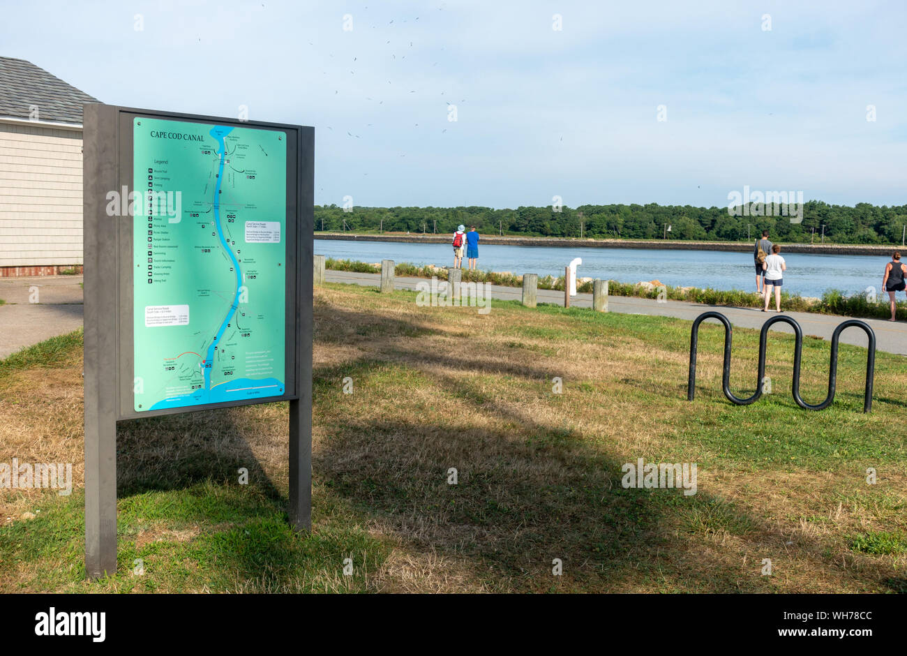 Cape Cod Canal map sign showing the points of interest & recreational areas with flock of seagulls in the sky during summer in Sandwich, MA Stock Photo