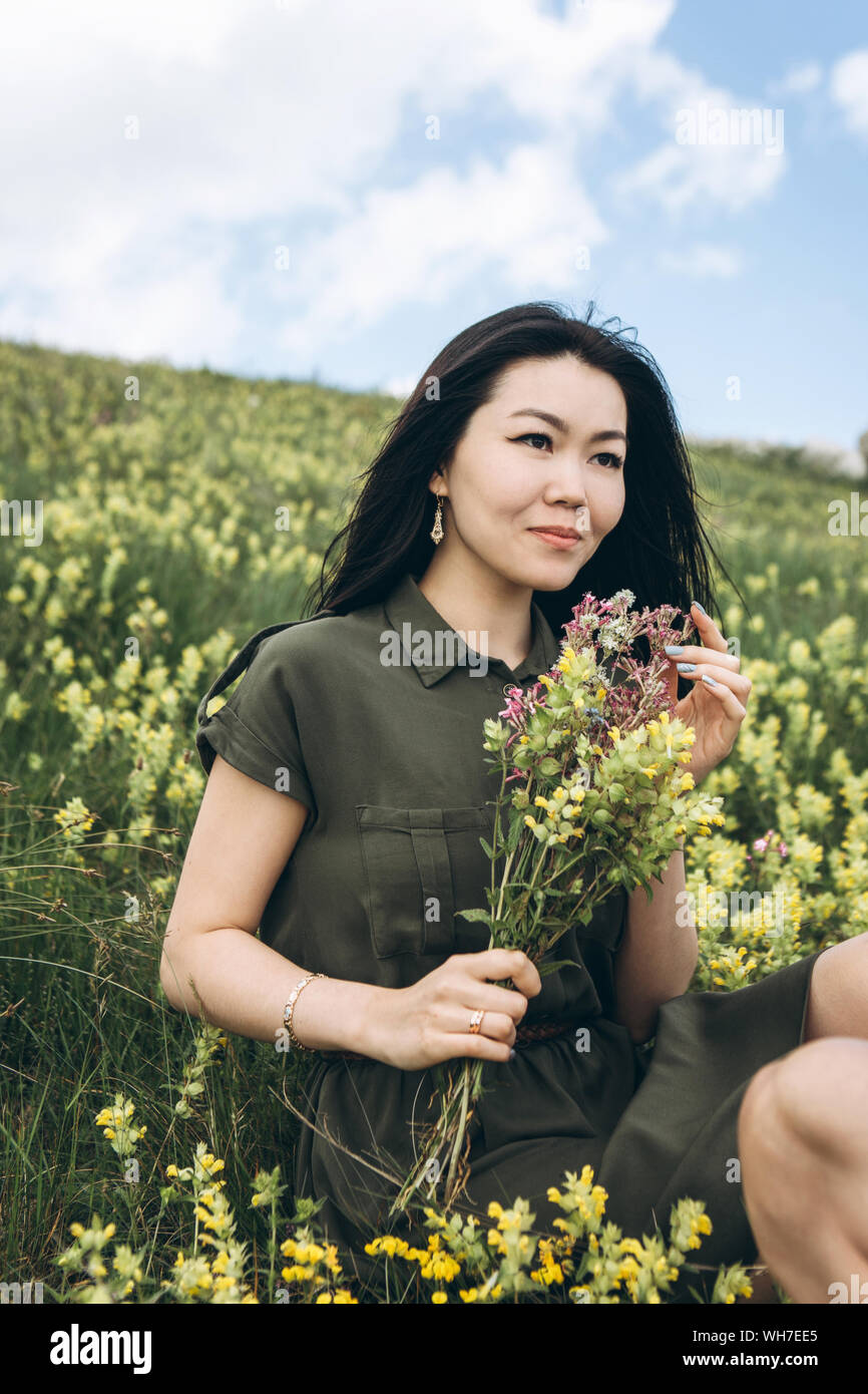 Beautiful girl with a bouquet of wildflowers in her hands. Stock Photo