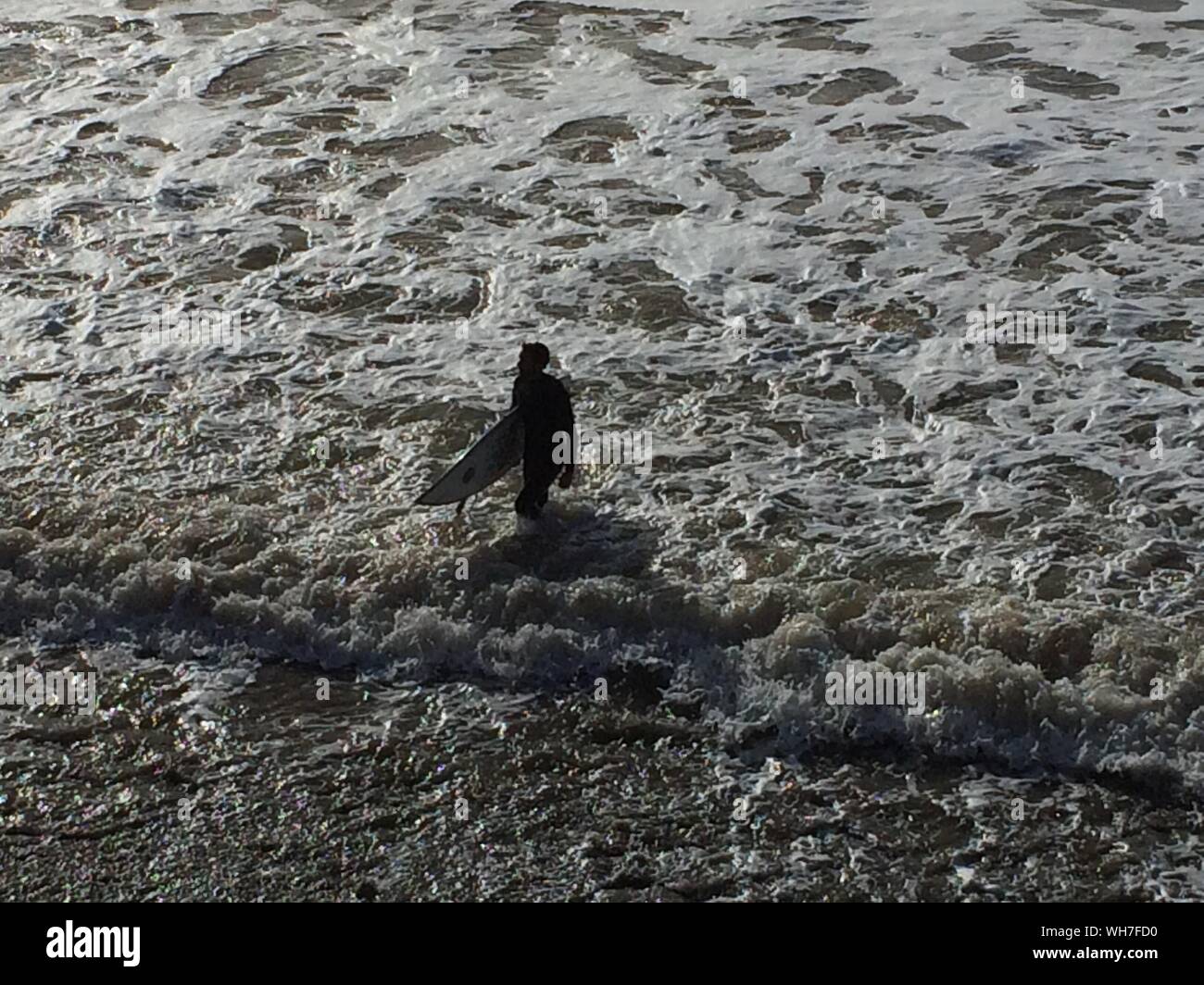 High Angle View Of Silhouette Man Walking On Sea Stock Photo
