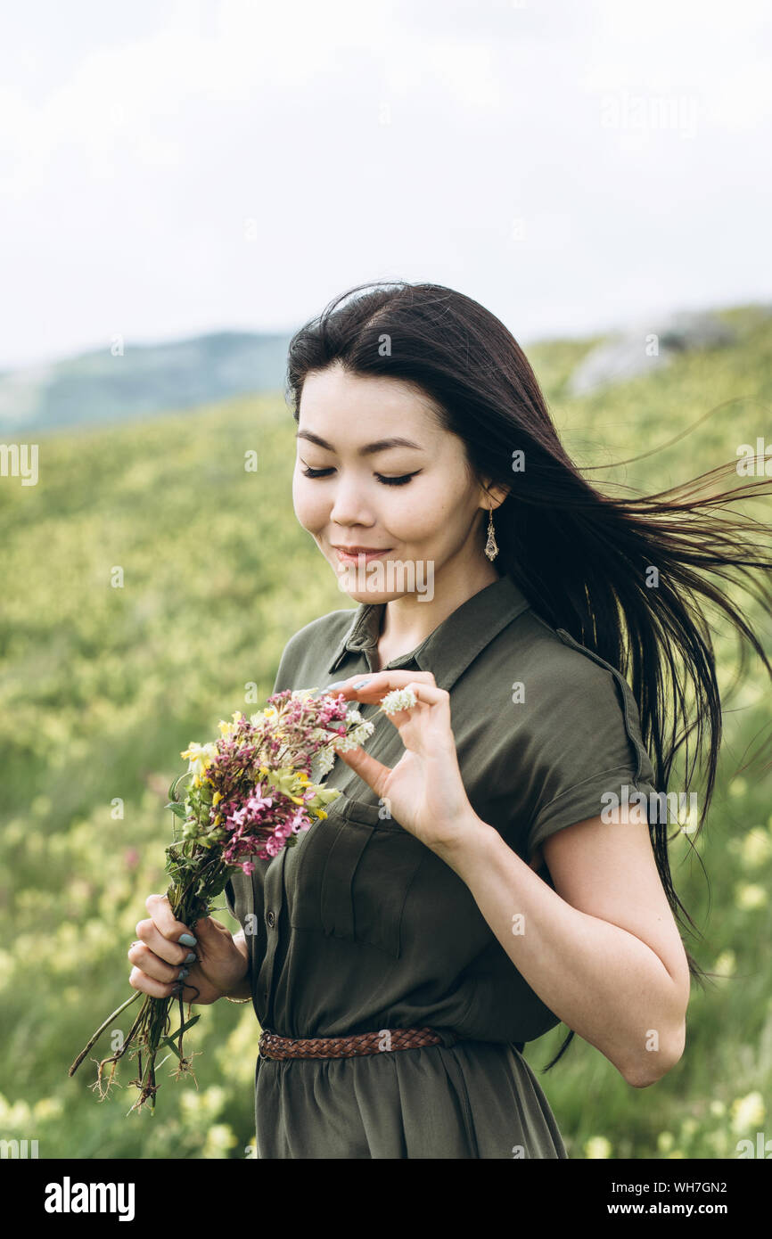 Beautiful girl with a bouquet of wildflowers in her hands Stock Photo ...