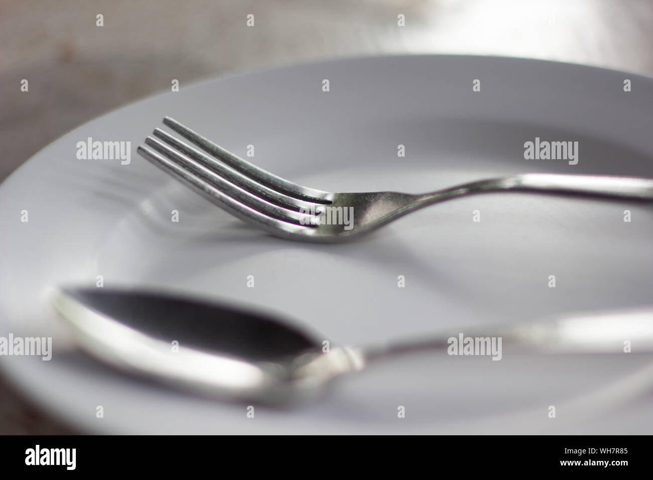 Close-up Of Fork And Spoon In Plate On Table Stock Photo