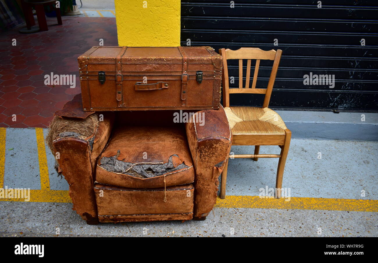 Old suitcase, sofa and chair on a street market Stock Photo