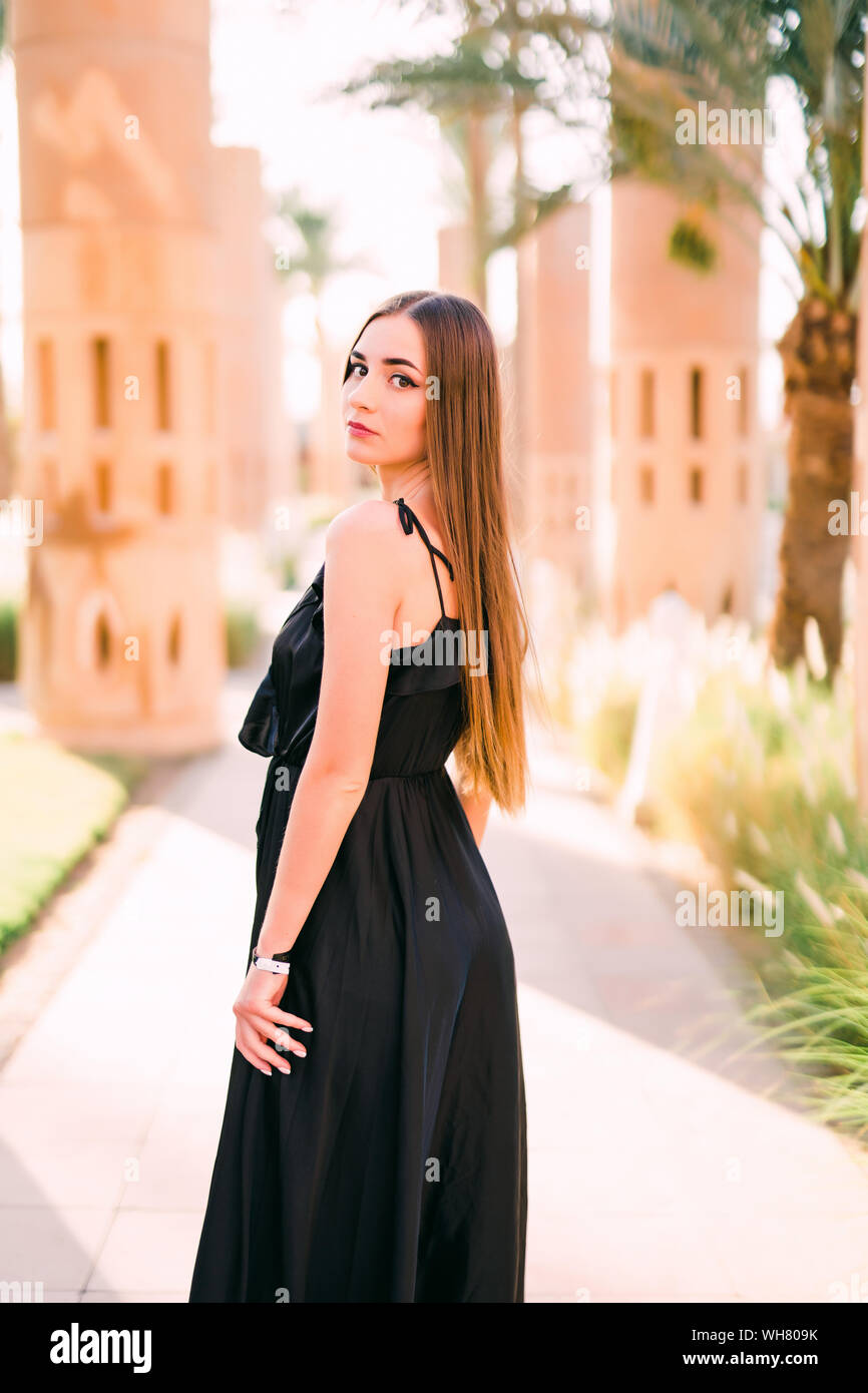 Young smiling woman in a black dress walking along the waterfront Stock ...