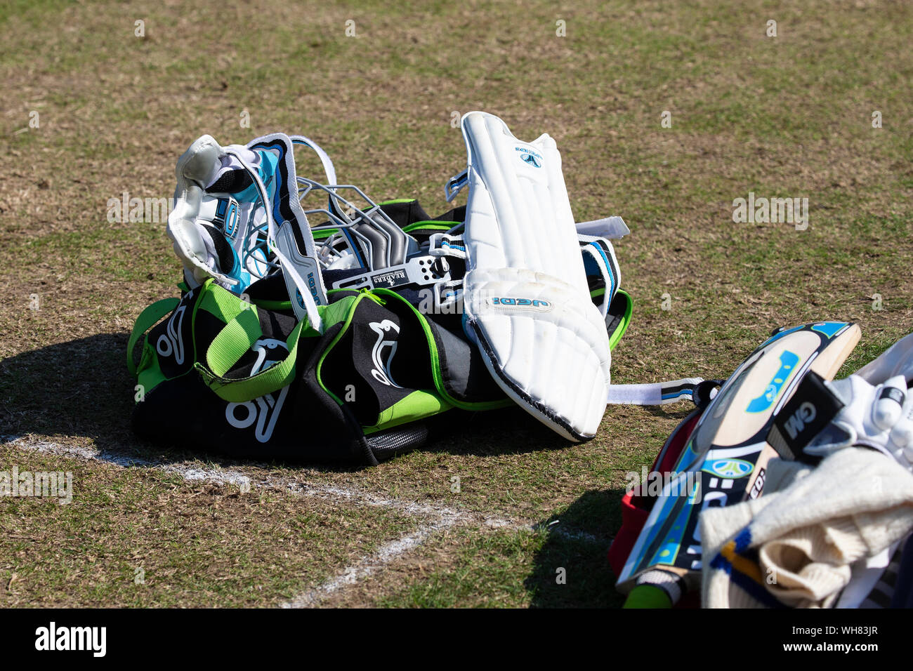 As assortment of cricket gear lying on the wicket and pitch during a break in play Stock Photo