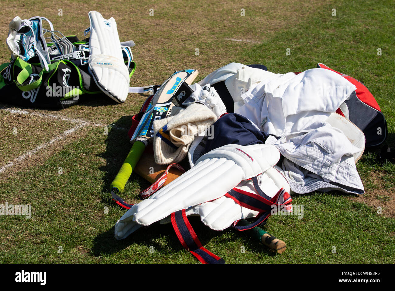 As assortment of cricket gear lying on the wicket and pitch during a break in play Stock Photo