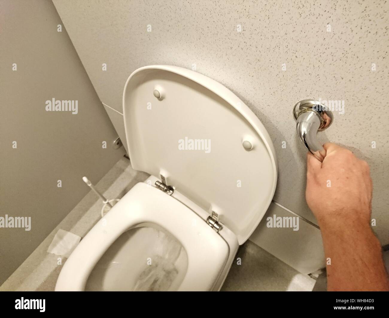 Cropped Image Of Man Flushing Toilet Stock Photo