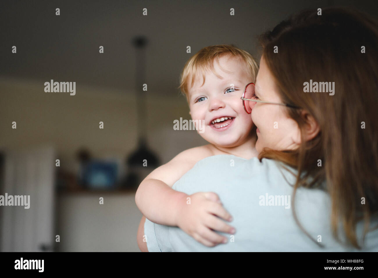 Portrait of little boy on his mother's arms at home Stock Photo