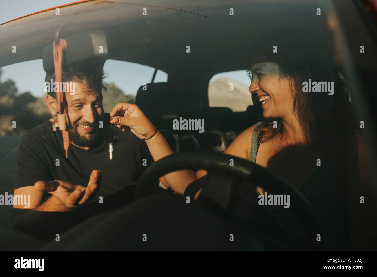 Couple exchanging car keys on a road trip Stock Photo