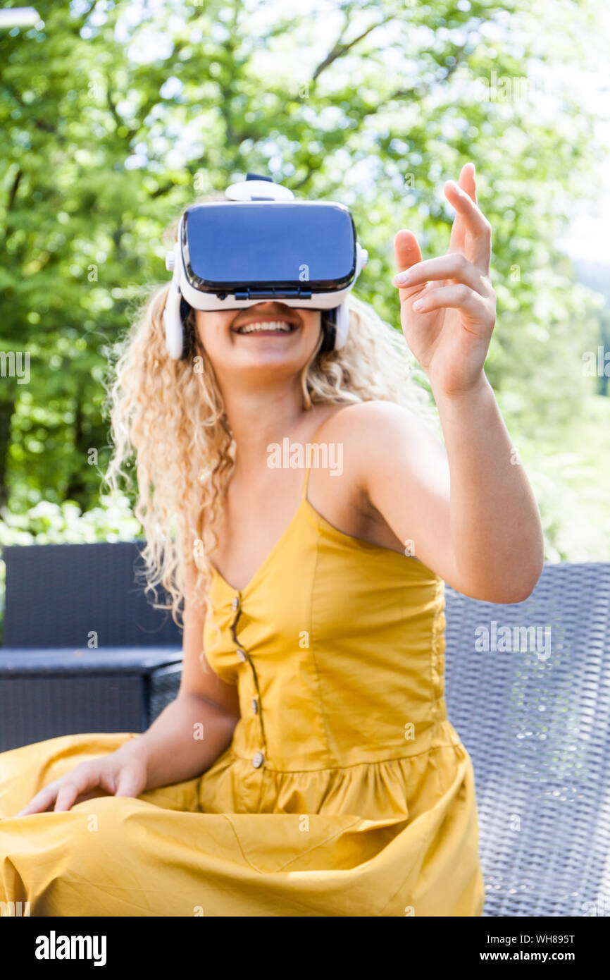 Young blond woman using virtual reality glasses outdoors Stock Photo