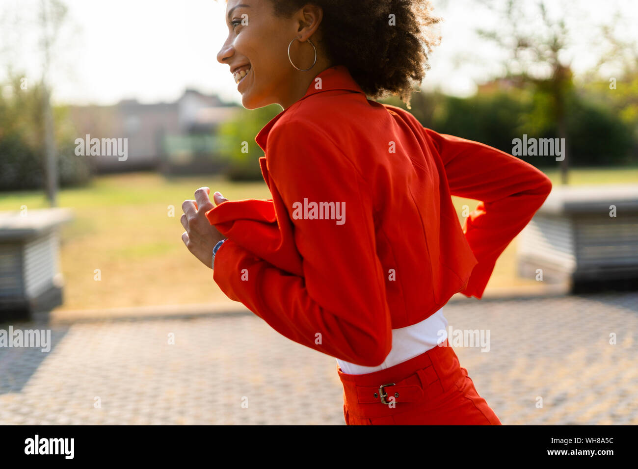 Running young woman wearing fashionable red pantsuit Stock Photo