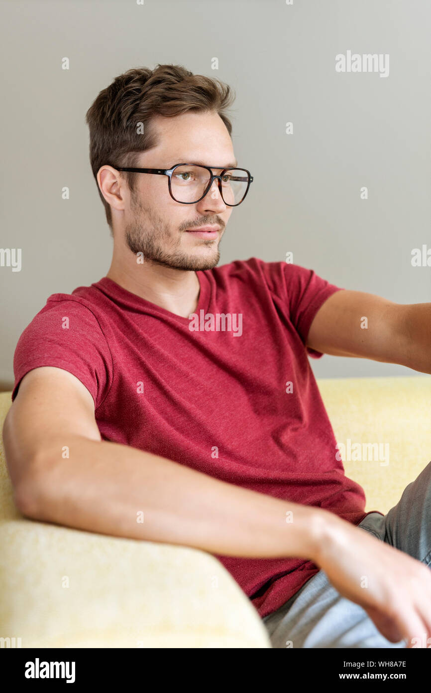 Pensive man sitting on a couch Stock Photo