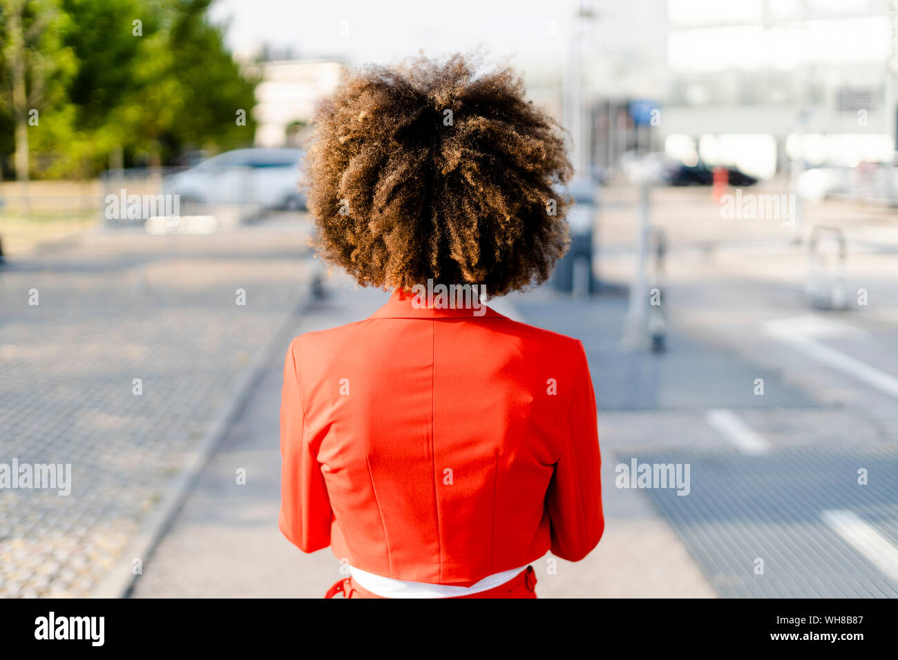 Back view of young woman wearing fashionable red suit jacket Stock Photo