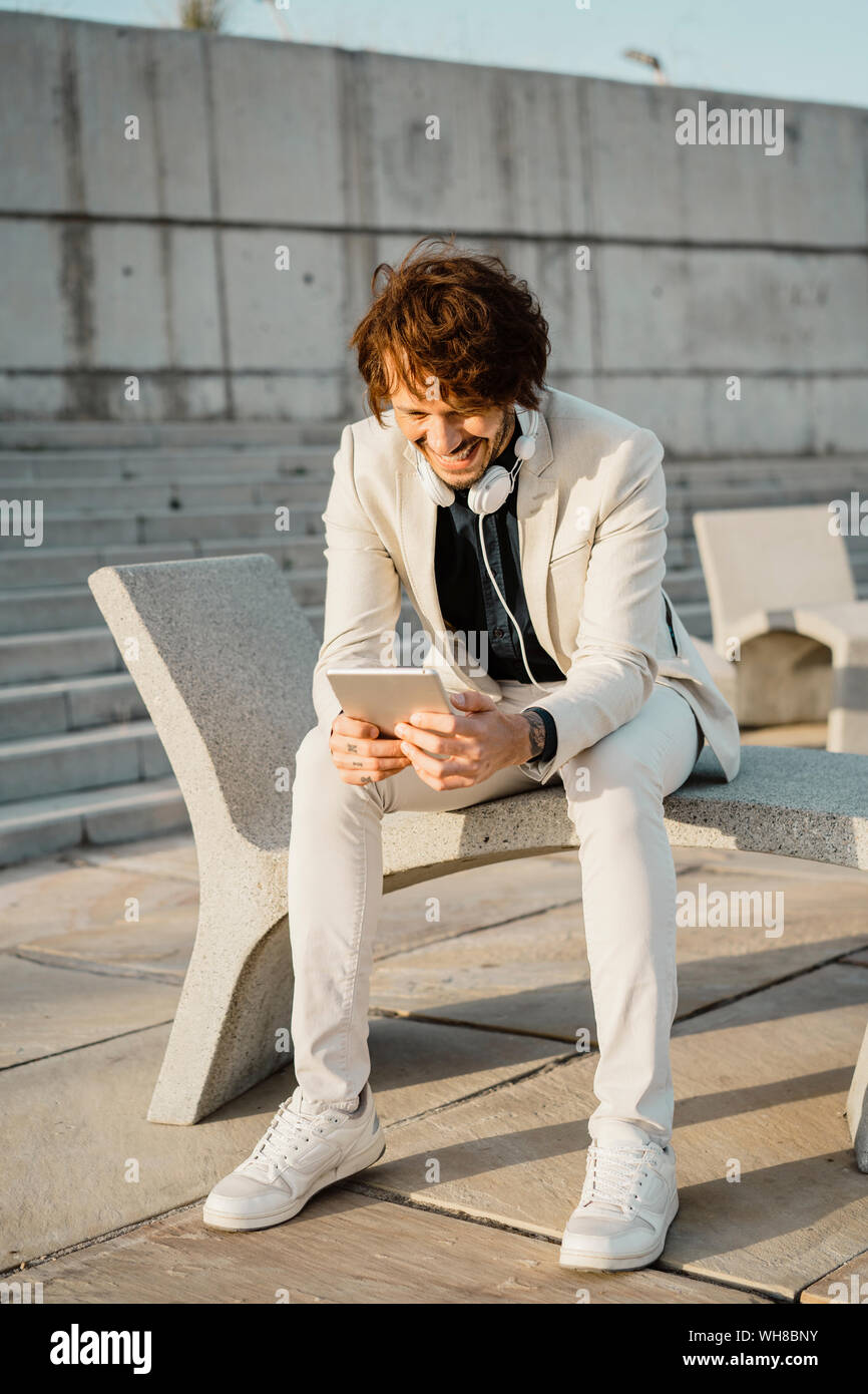 Laughing businessman using digital tablet outdoors Stock Photo