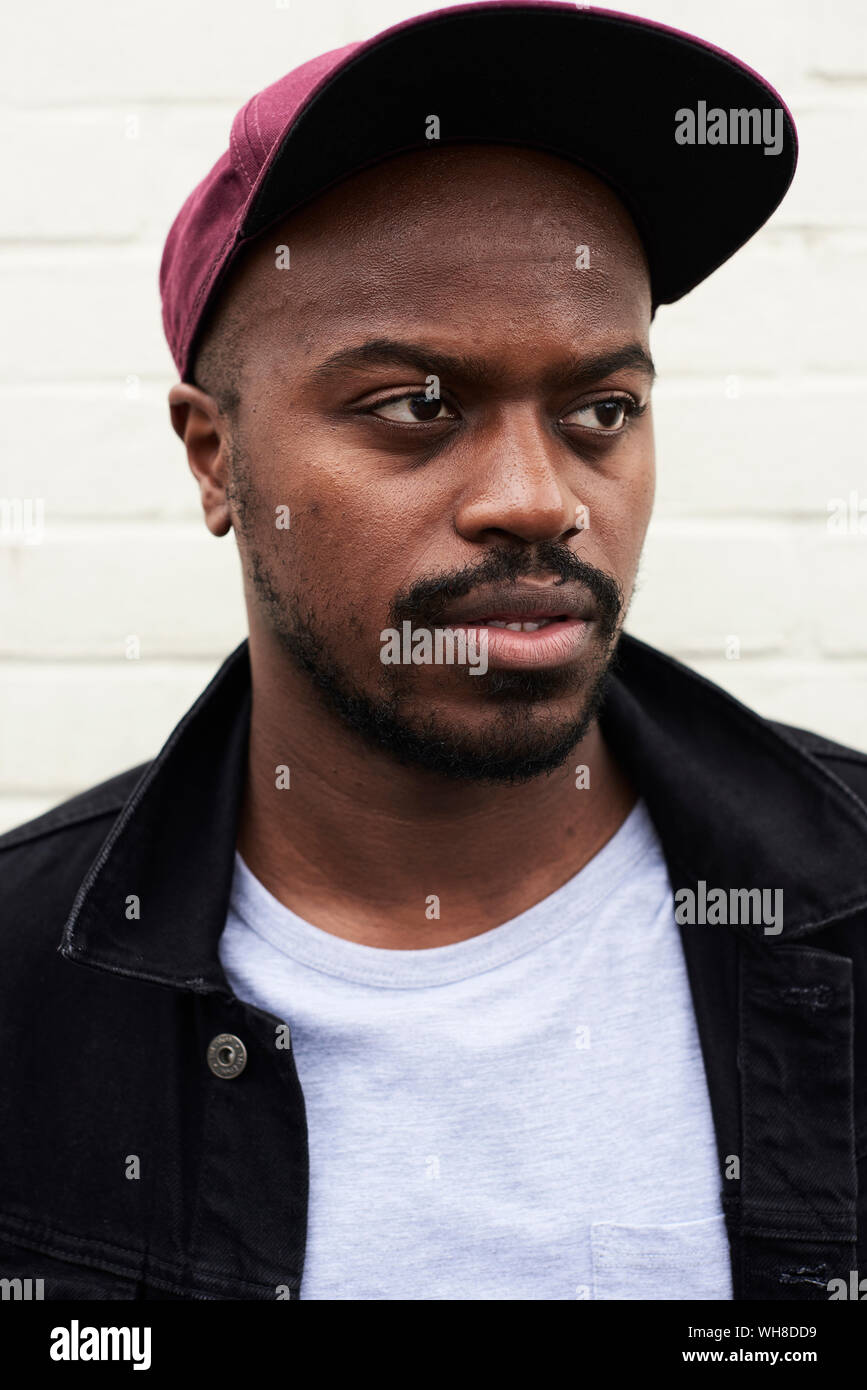 Portrait of mid adult man wearing denim jacket and basecap Stock Photo