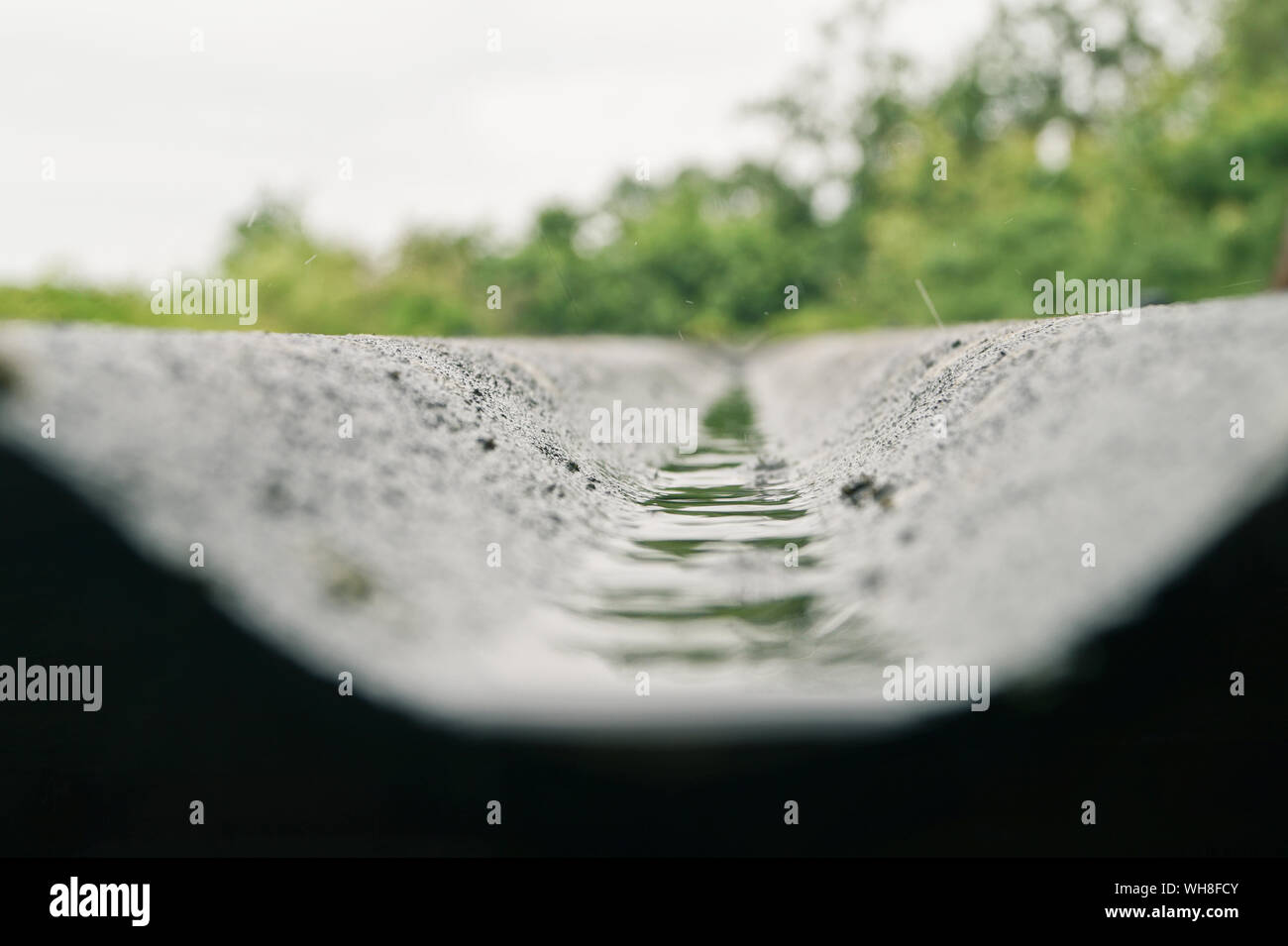Low Angle View Of Rain Water Moving Down From Roof Stock Photo