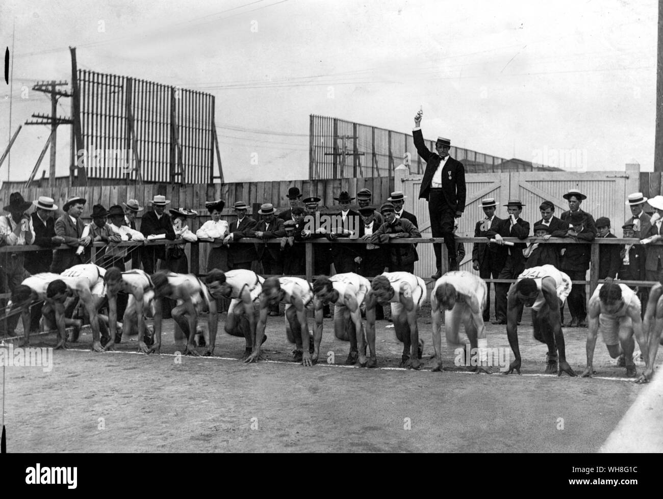 A crowded 400 metres final, for which the starter perches on a fence for a better view of the field. World's Fair, 1904, Olympic Games, St Louis. The Olympic Games page 50. Stock Photo