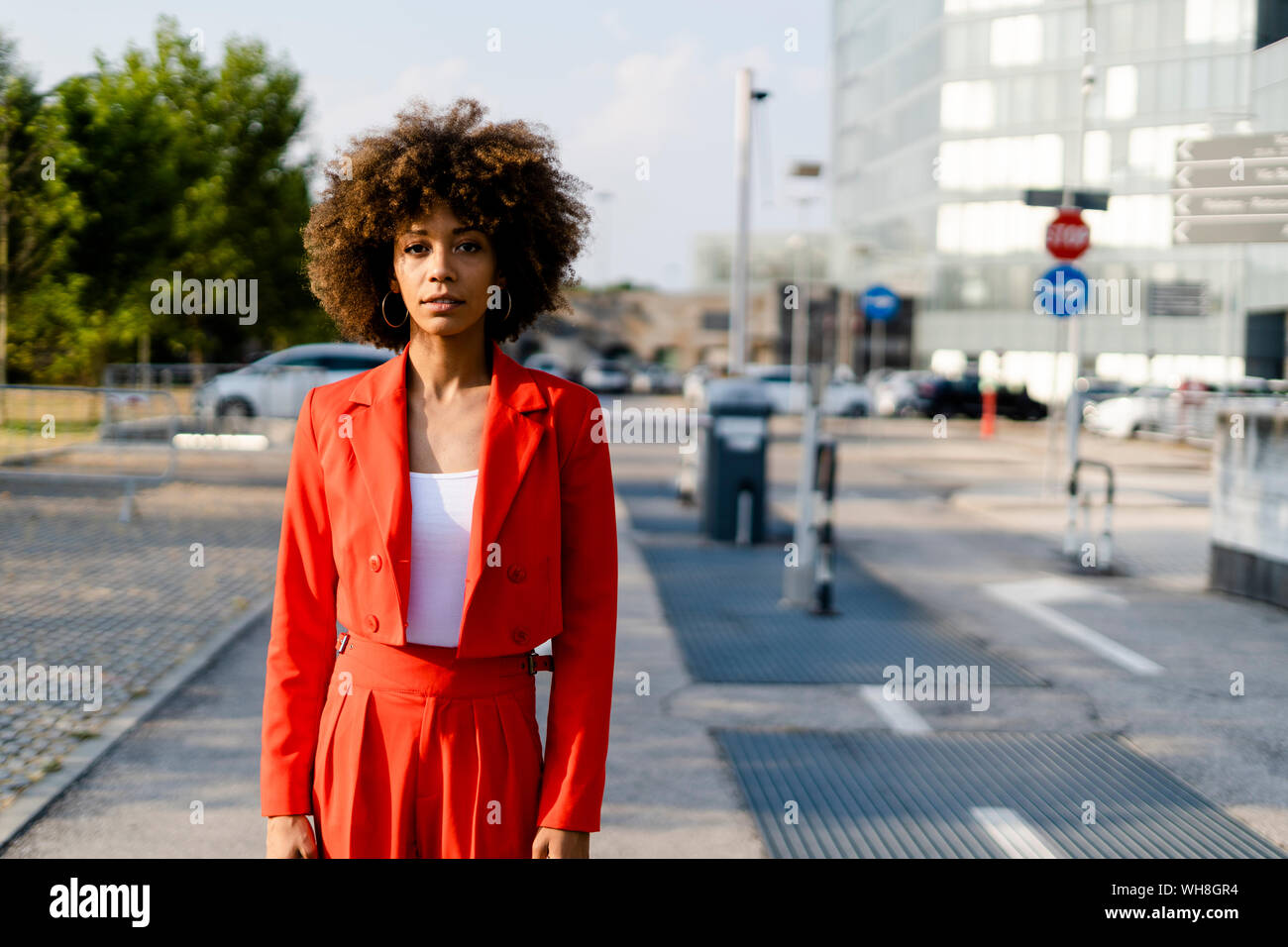 Portrait of young woman wearing fashionable red pantsuit Stock Photo