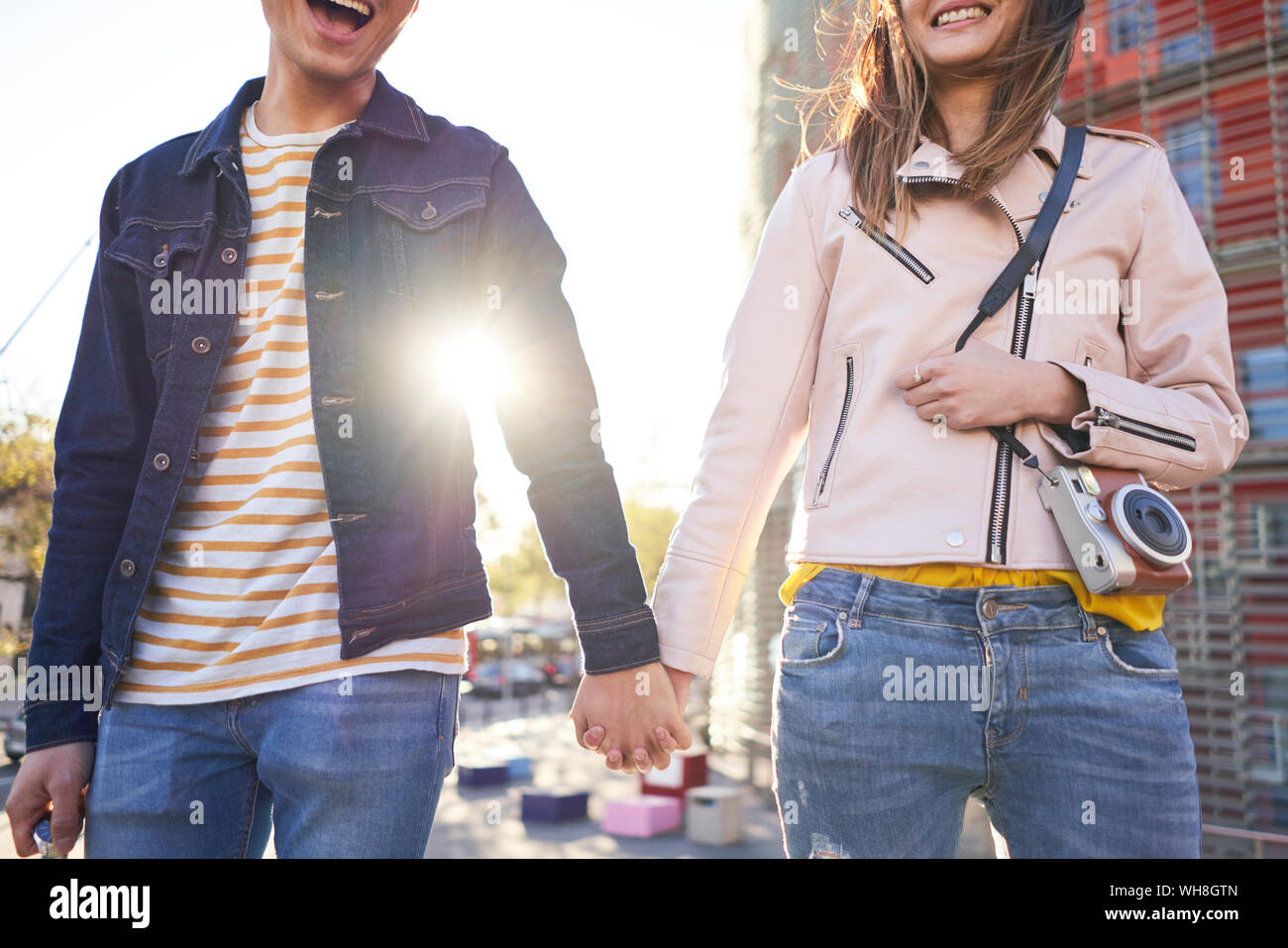 Laughing couple walking hand in hand in the evening, Barcelona, Spain Stock Photo