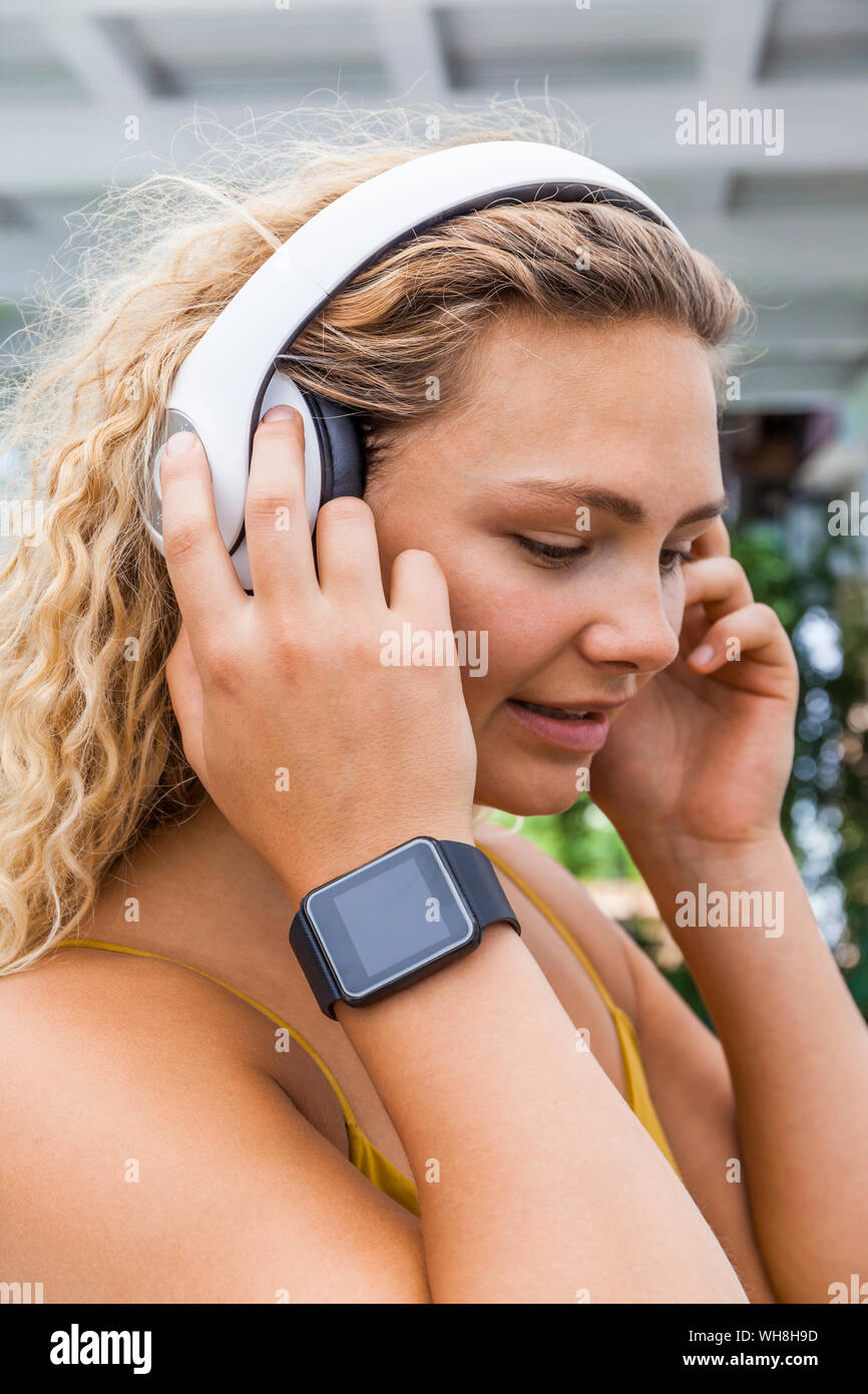 Smiling woman listening to music, smartwatch Stock Photo