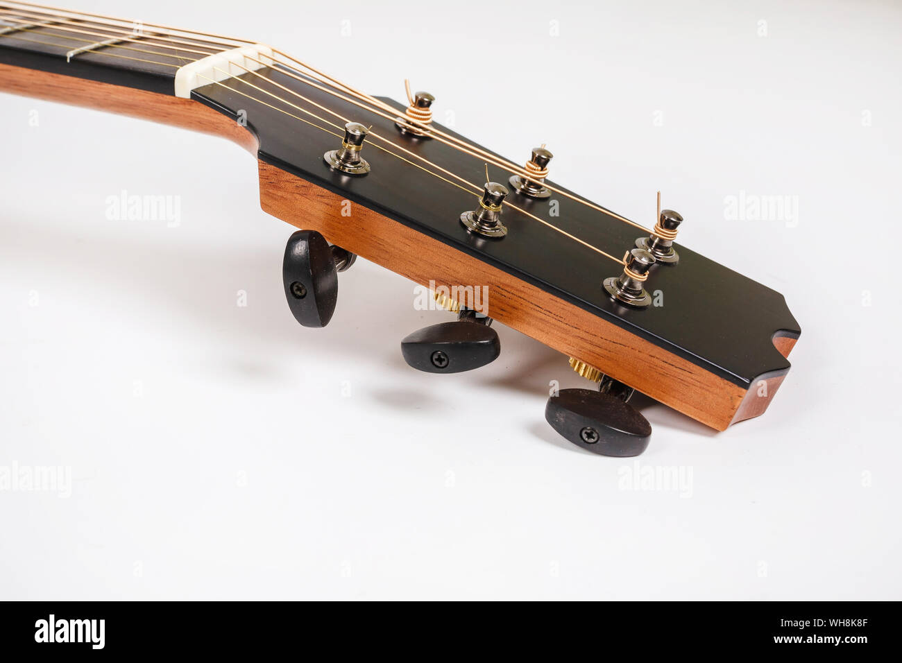 Tuning pegs on wooden machine head of six strings guitar on white background Stock Photo