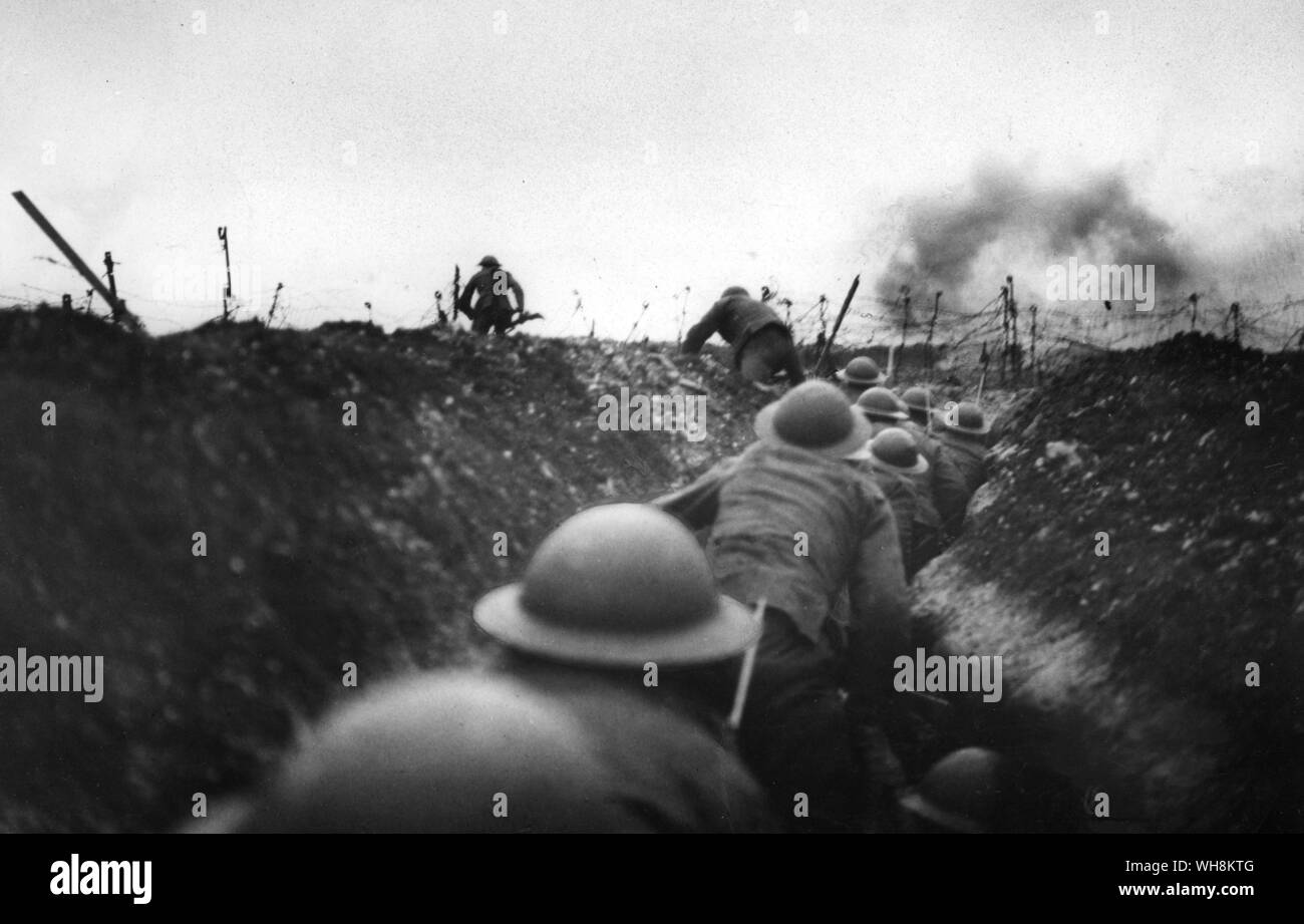 An officer leads the way out of the sap and is being followed by party. Shells bursting . British troops go over the top 1917 Stock Photo