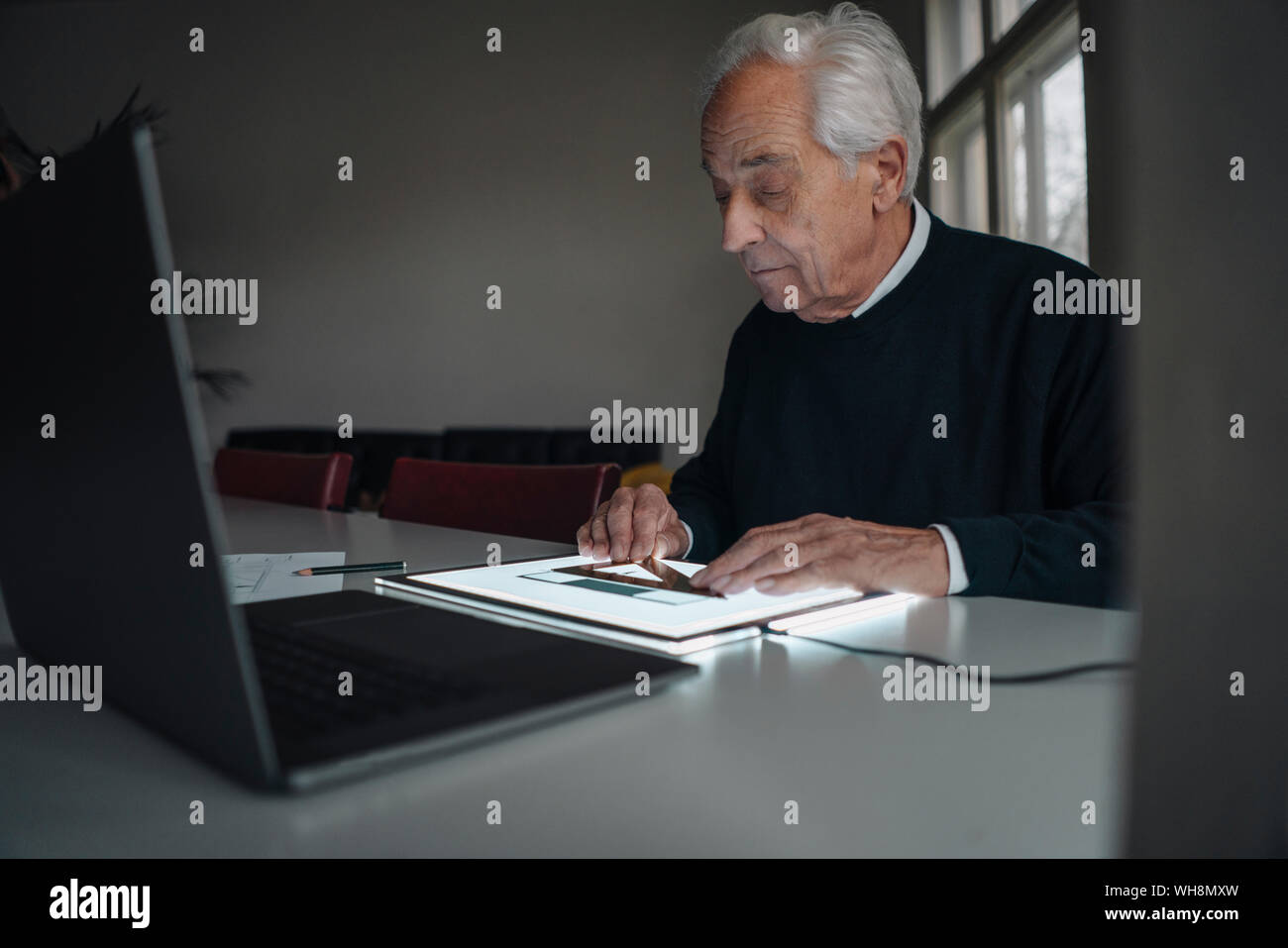 Senior man using tablet with architectural plan Stock Photo