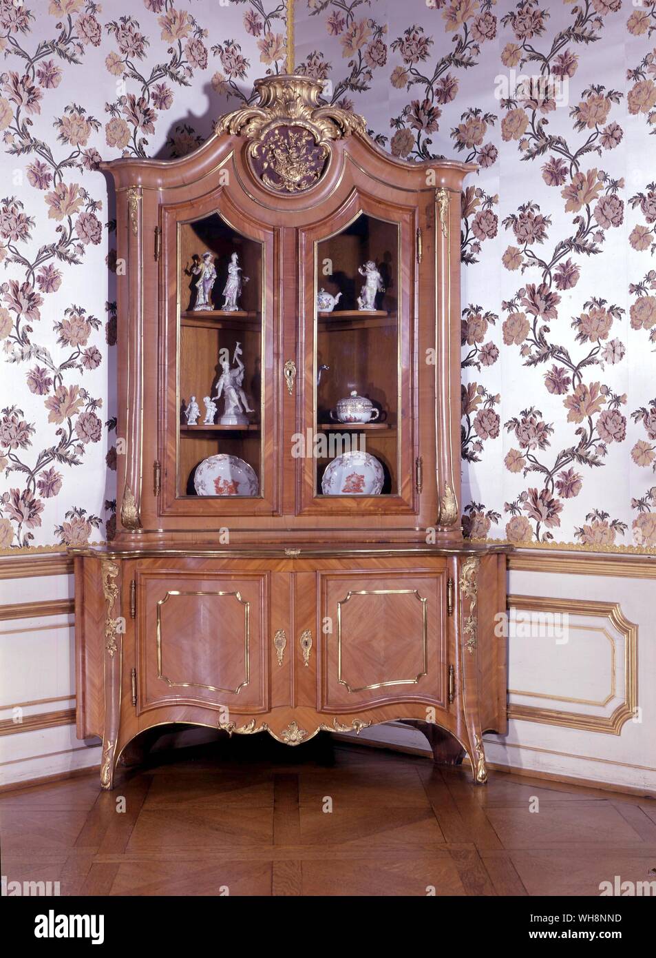 A corner cupboard of cedar wood with bronze fittings by J. A. Nahl, Berlin, about 1745, after a design by Knobelsdorff. The Berlin porcelain includes a shepherd and shepherdess by F. E. Meyer. a Gotzkowski teapot. a cherub from the service of the Potsdam palace. Fama, also by F. E. Meyer. two figures by C. W. Meyer and two plates from the Charlottenburg service. Stock Photo