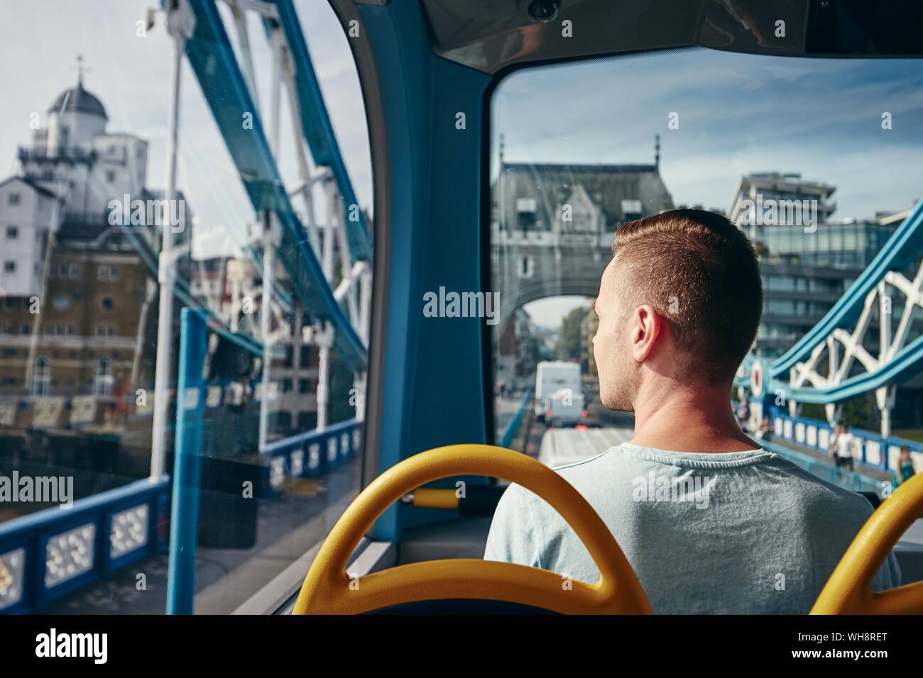 Young man looking through window from double decker bus. City life in London, United Kingdom. Stock Photo