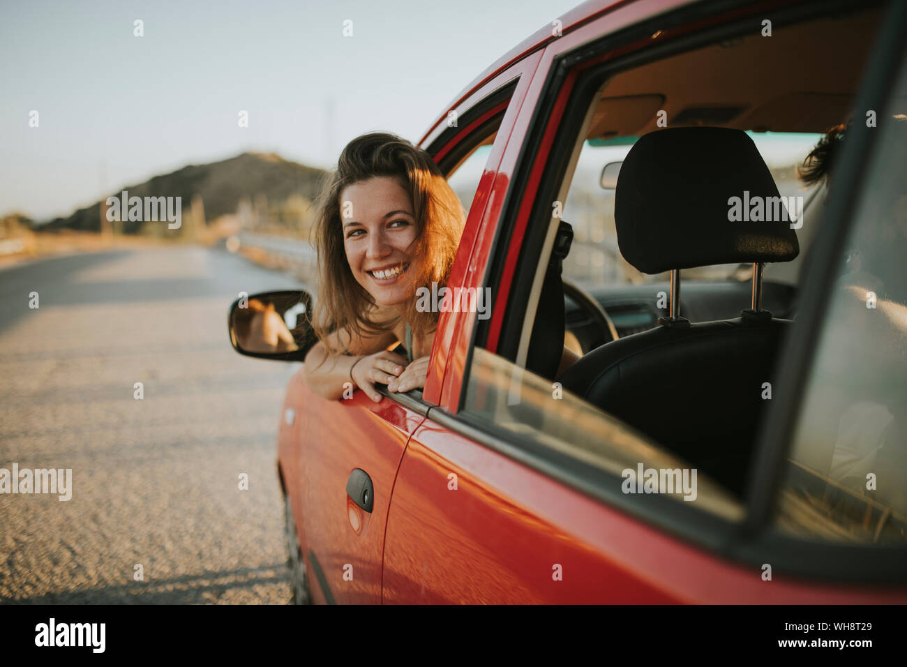 Woman on a road trip looking out of car window Stock Photo - Alamy