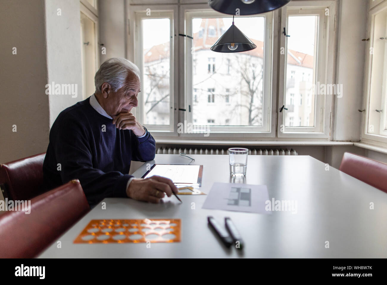 Senior man using tablet with architectural plan Stock Photo