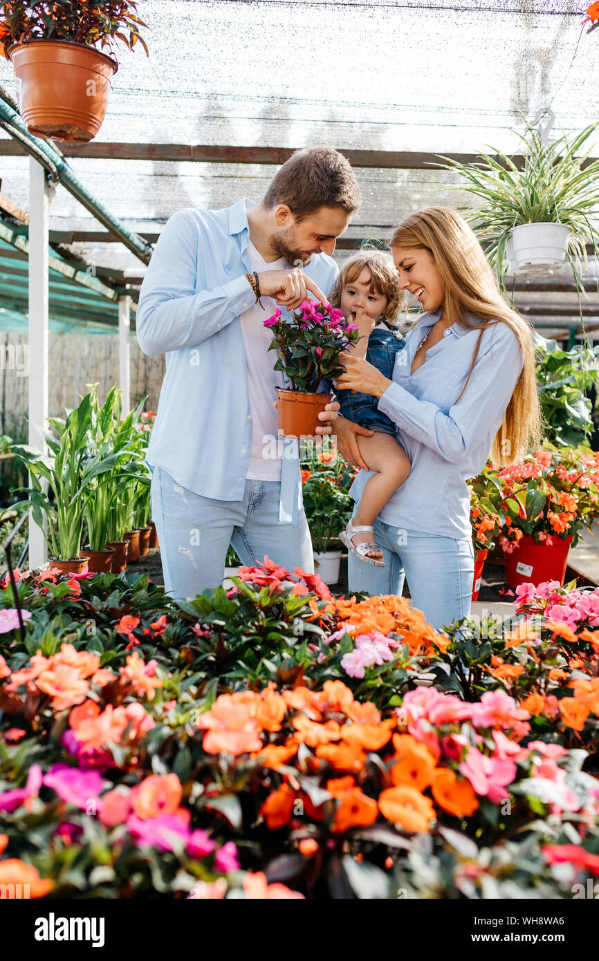 Happy mother, father and daughter buying flowers in a garden center Stock Photo