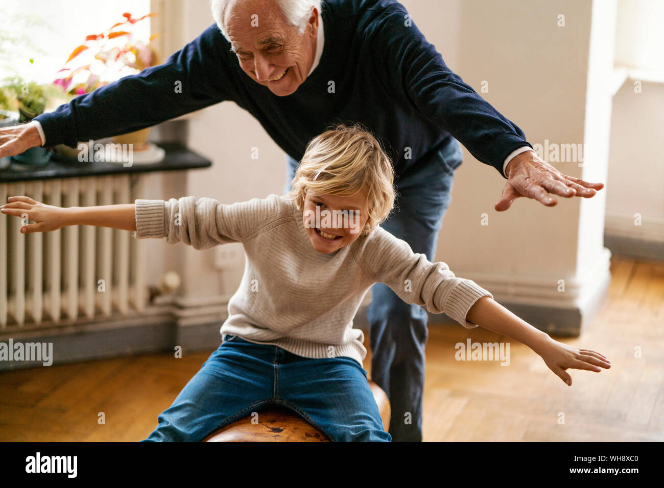 Happy grandfather and grandson playing with buck at home Stock Photo