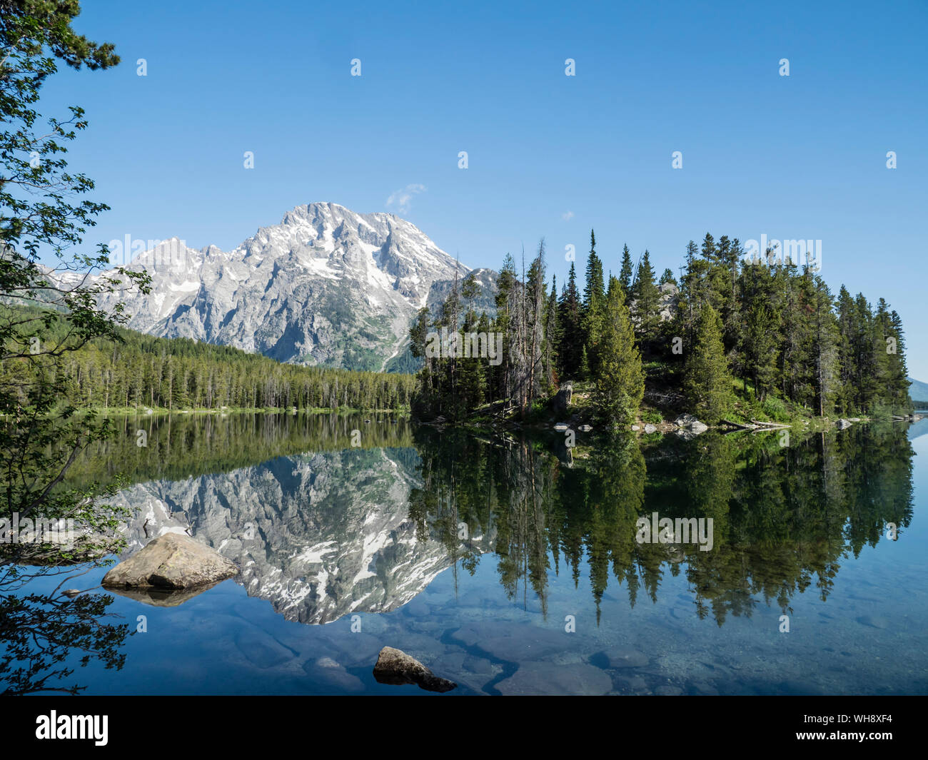Snow-capped mountains reflected in the calm waters of Leigh Lake, Grand Teton National Park, Wyoming, United States of America, North America Stock Photo
