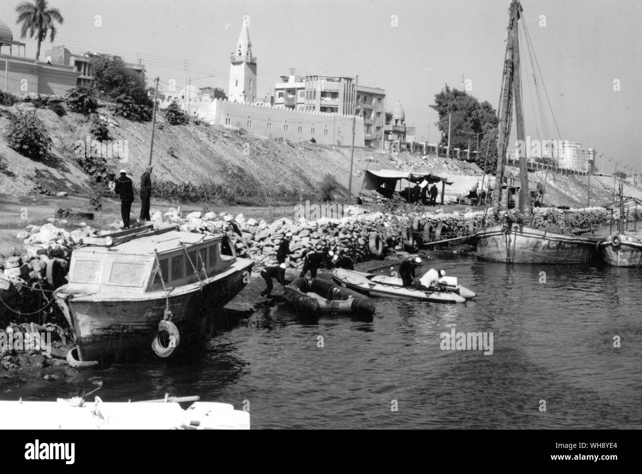 River Police Station. 'The place was on the slope of the levee with two shacks, some ramshackle boats and dozen young men who were dressed in seamen's uniforms which were ragged and dirty'. Egypt. Stock Photo