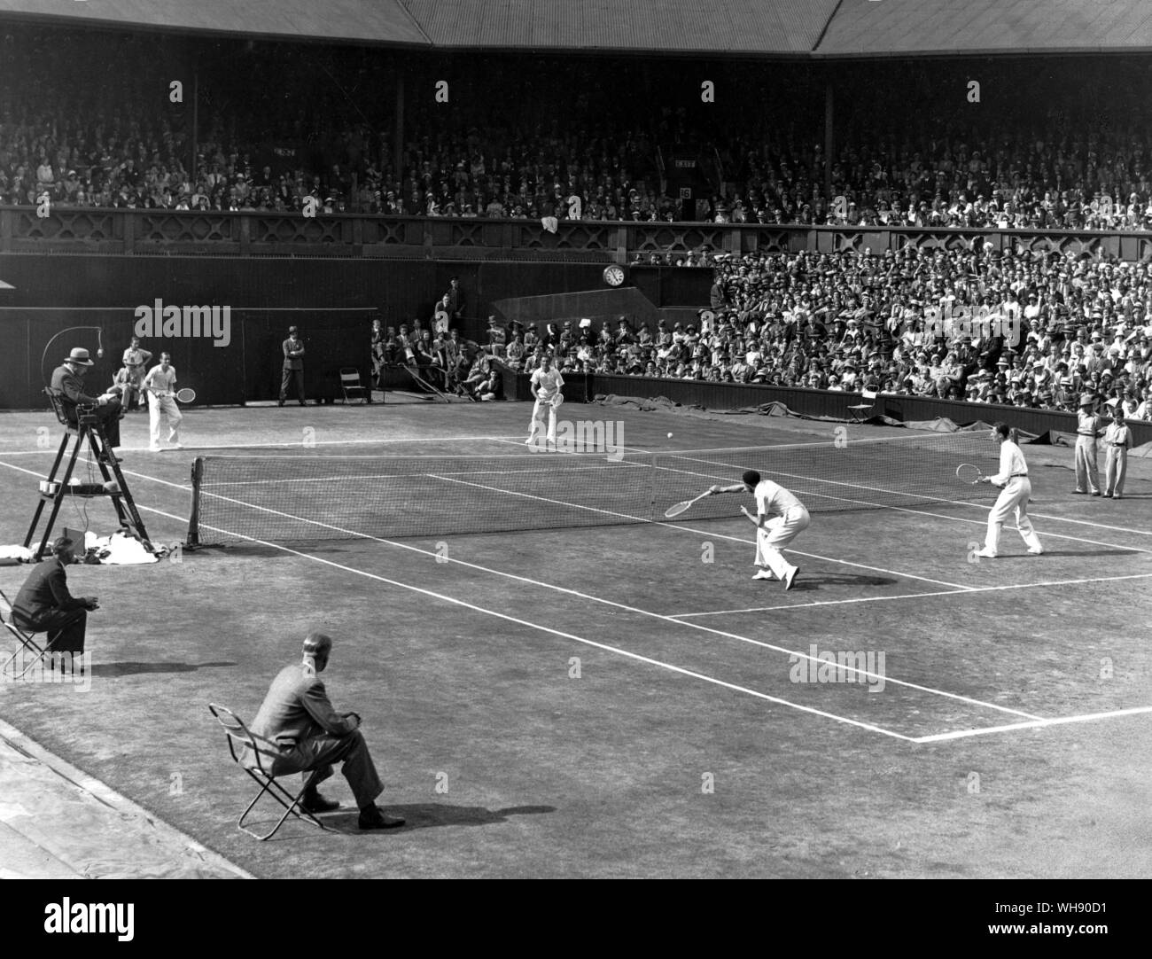 Two of the musketeers, Jacques Brugnon (r) and Jean Borotra (near side of net) playing Fred Perry (r) and Patrick Hughes. Wimbledon 1932.. . Stock Photo