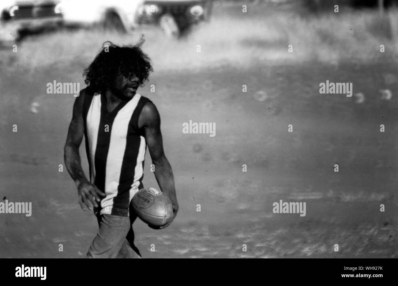 A young Arunta capture the ball during Australian Rules football match at Hermannsburg Stock Photo
