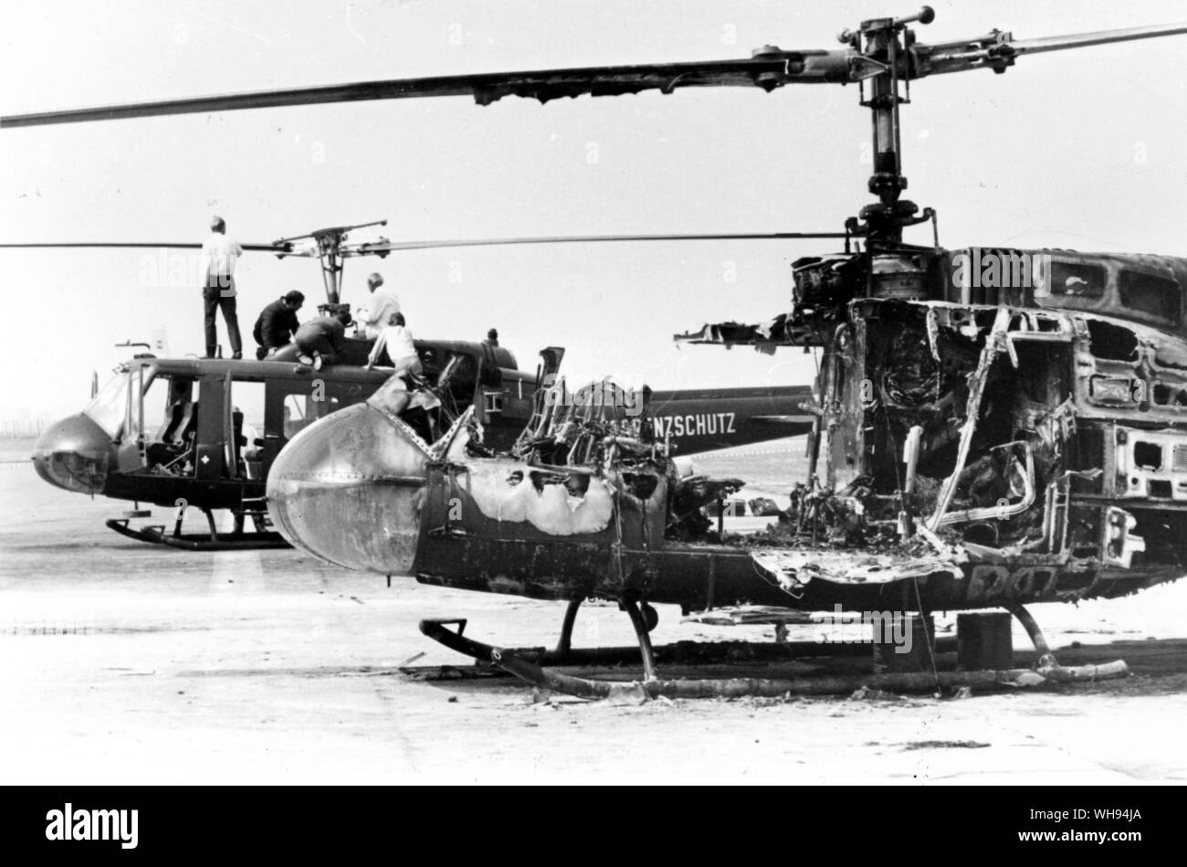 Incident at the Munich Olympics, 1972. Helicopter wreckage. Experts examine the wreckage of two German Border Police helicopters at Fuerstenfeldbrueck, near Munich. The helicopter in the foreground is burnt out after a hand grenade explosion. Nine Israeli Olympic athletes dies in a shoot out between their Palestinian captors and German Police.. Stock Photo