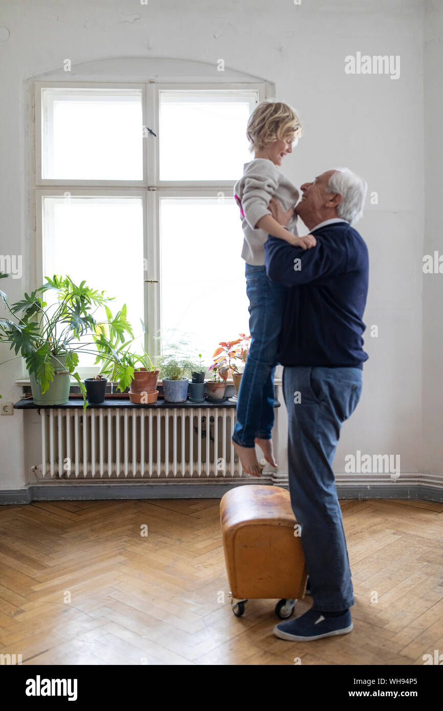 Grandfather lifting up grandson at home Stock Photo