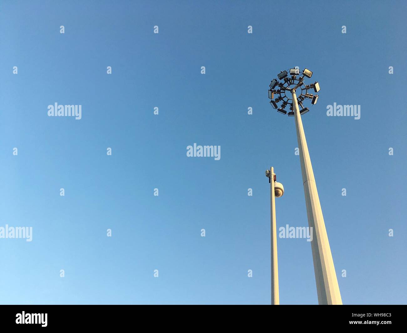 Low Angle View Of Floodlights Against Clear Blue Sky Stock Photo