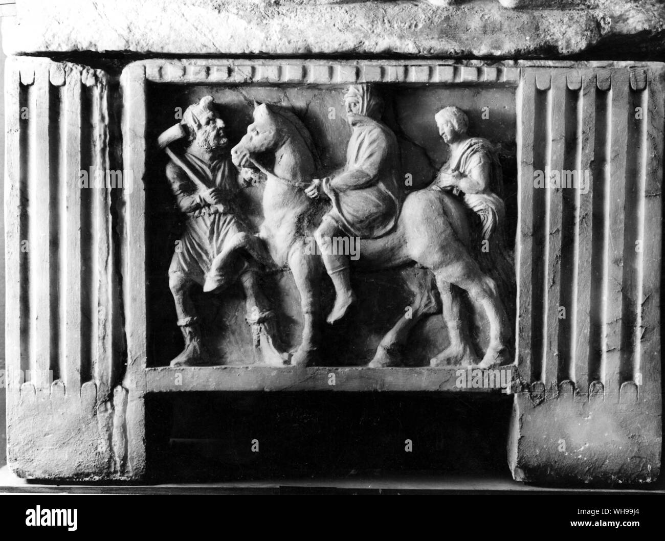 Scene from a alabaster urn found at Volterra A magistrate is being led away by Charun the Underworld demon with his hammer Stock Photo