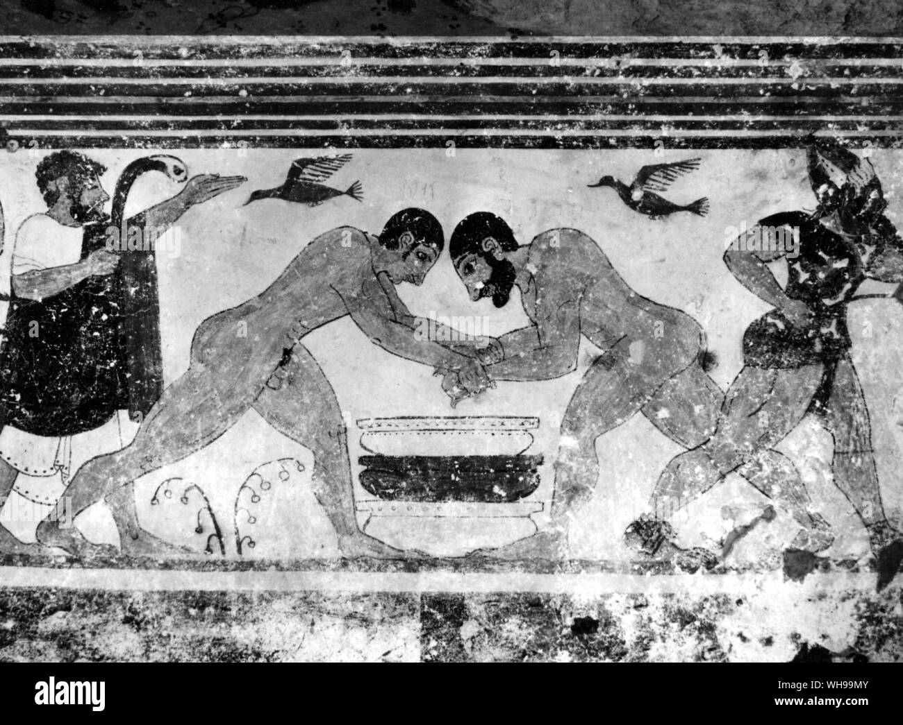 Detail from painting in the Tomb of the Augurs Tarquinia. Two wrestlers are accompanied by an augur who watches the fight of the birds Stock Photo