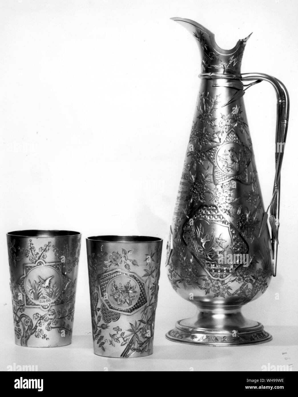 Jug and beakers in silver by Elkington, 1882. A demonstration of the unerring choice of all the worst aspects of Japanese design grafted onto a quasi-Moorish shape. Stock Photo