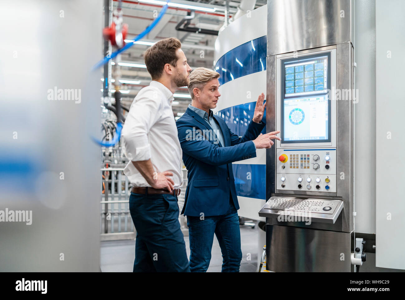Two businessmen talking in a modern factory Stock Photo - Alamy